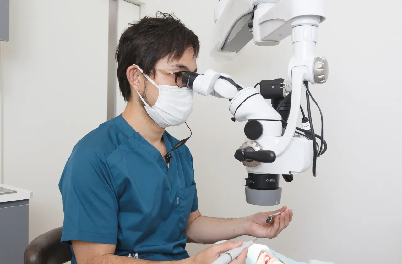 歯科用顕微鏡を用いて治療する三澤院長